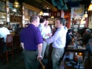 a group of men socializing near the bar