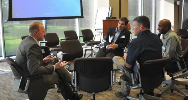 4 men sitting in a circle talking