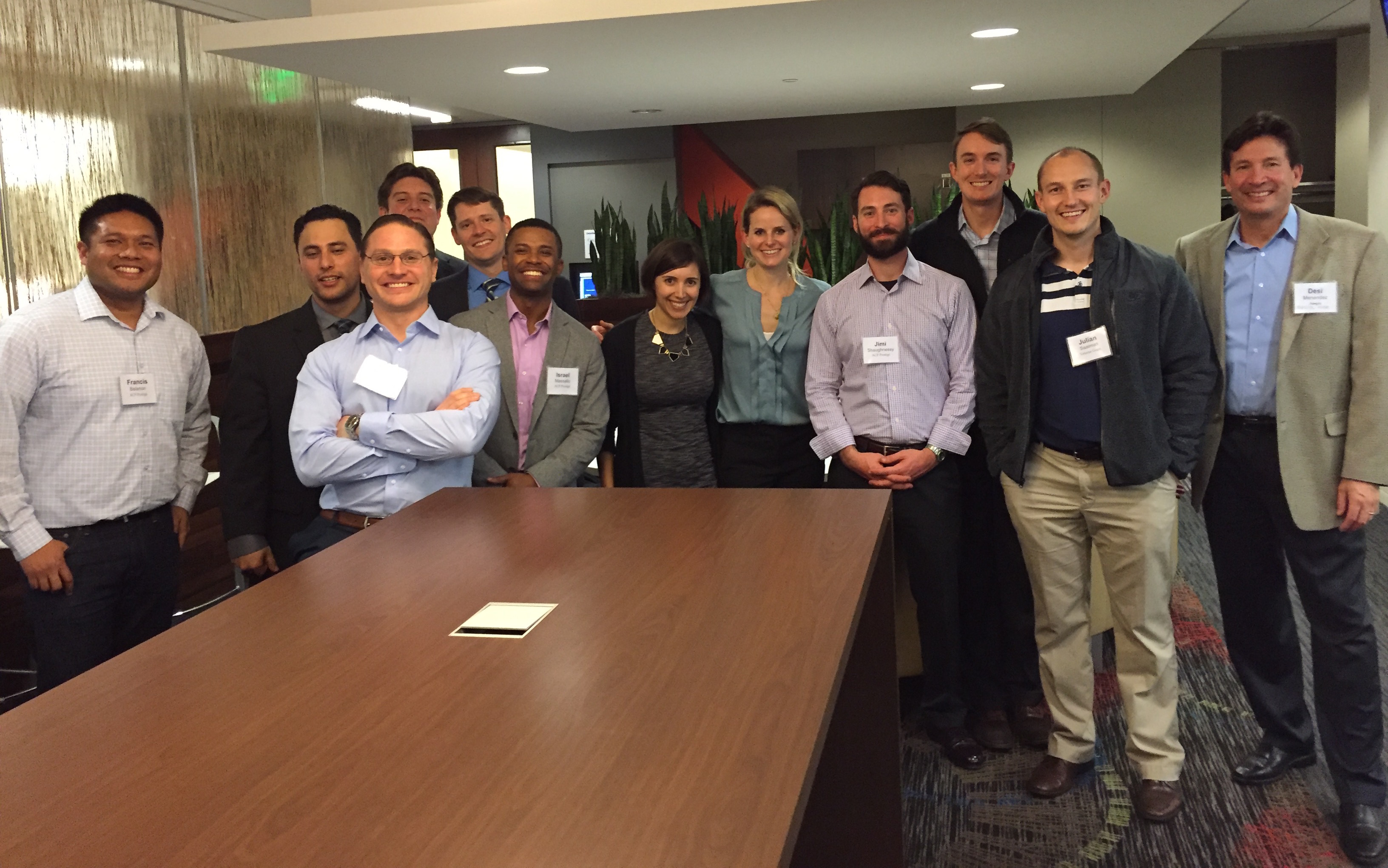 group of people standing behind large conference table