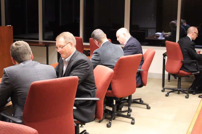 Men in suits sitting in pairs, talking