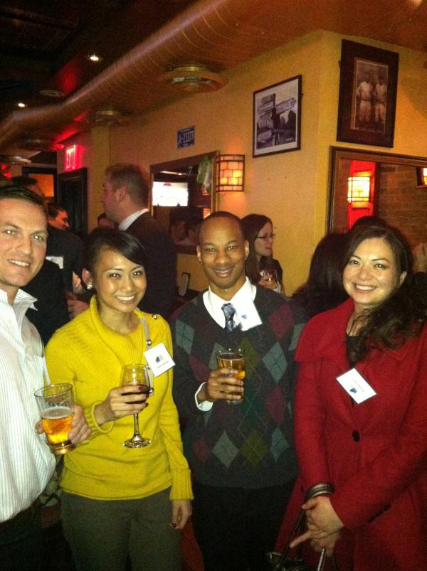 4 of the attendees posing together with glasses of wine