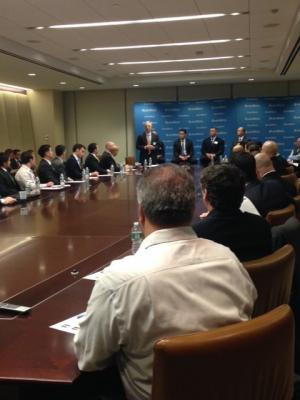 people sitting around a large conference table listening to the speakers